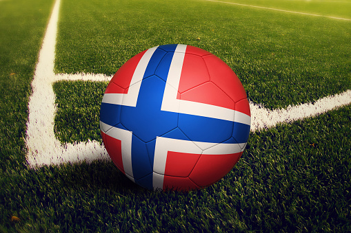 Norway ball on corner kick position, soccer field background. National football theme on green grass.