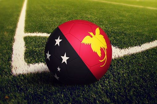 Papua New Guinea ball on corner kick position, soccer field background. National football theme on green grass.