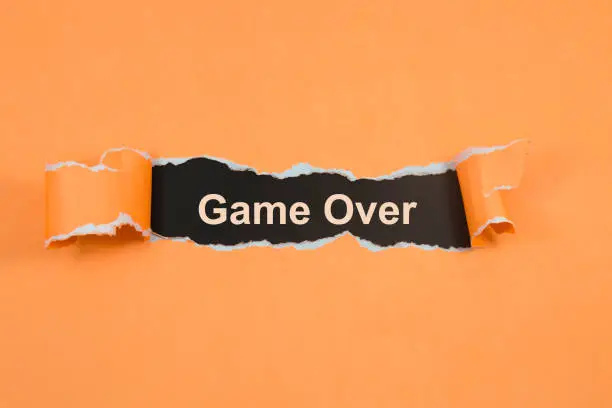 Photo of The word time to game over appearing behind torn paper