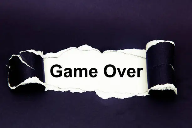 Photo of The word time to game over appearing behind torn paper