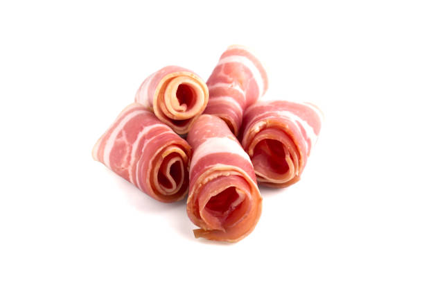 istock Slices of bacon on a white background. Raw rolled bacon on a white background. 1129198531