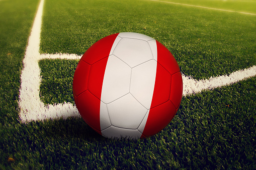 Peru ball on corner kick position, soccer field background. National football theme on green grass.