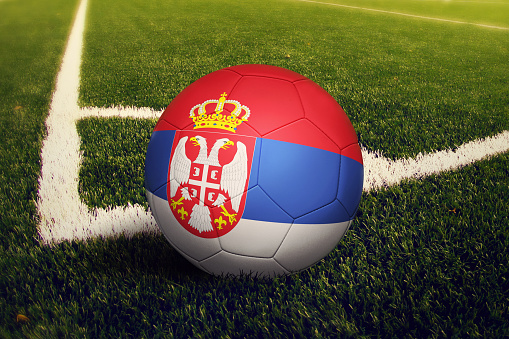 Serbia ball on corner kick position, soccer field background. National football theme on green grass.