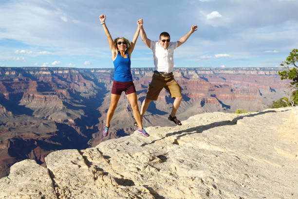 istock Young couple jumping over the Grand Canyon 1129200978