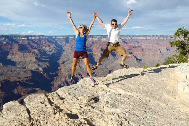 istock Young couple jumping over the Grand Canyon 1129200981