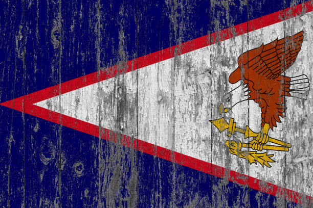 Flag of American Samoa painted on worn out wooden texture background.