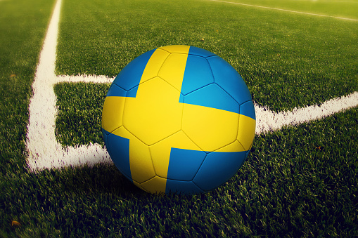 Sweden ball on corner kick position, soccer field background. National football theme on green grass.