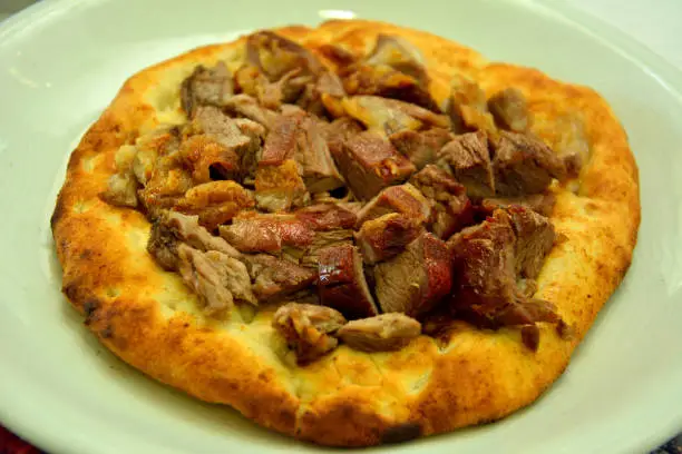 Buryan (lamb slow-cooked in a pit) served on a flat bread in Turkey.