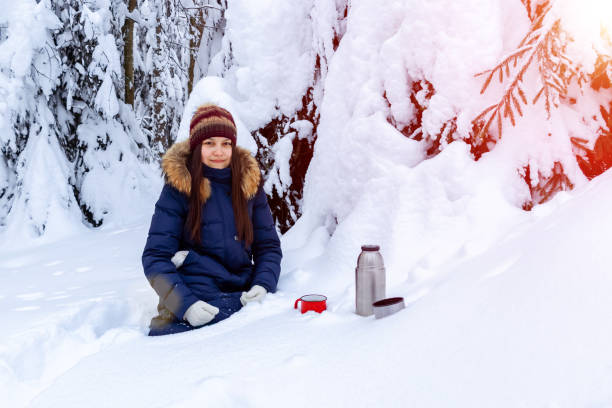istock girl drinks coffee from a thermos while walking through a snowy winter forest 1129202640