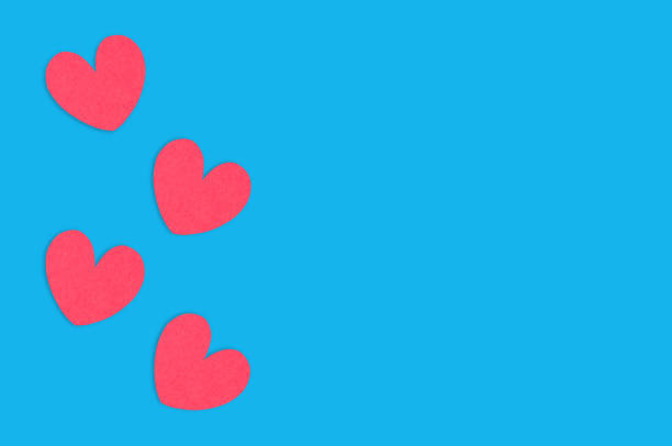 istock Four red paper hearts on blue table. Top view. Valentines Day concept. Copy space for your text 1129203914