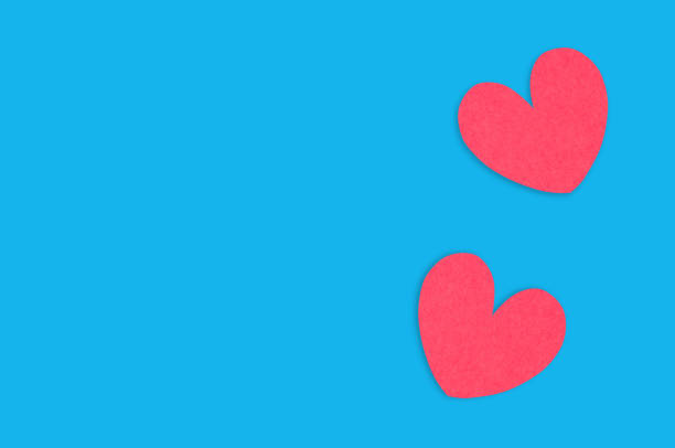istock Two red paper hearts on blue table. Top view. Valentines Day concept. Copy space for your text 1129203916