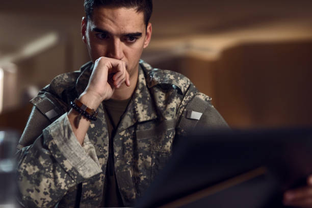 Young soldier feeling homesick while looking at photo in picture frame.
