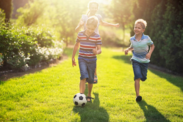 istock Kids having fun playing soccer in the backyard 1129209367