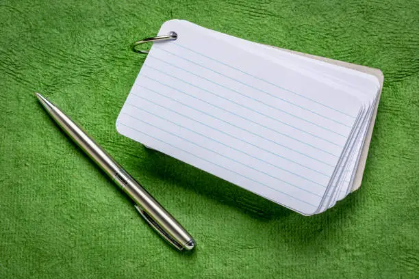 blank index cards with a pen against green textured paper