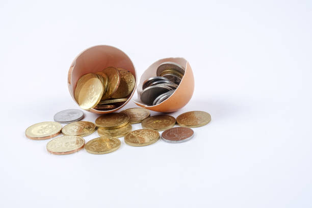 istock Close-Up Of Coins And Eggshell On White Background 1129210927