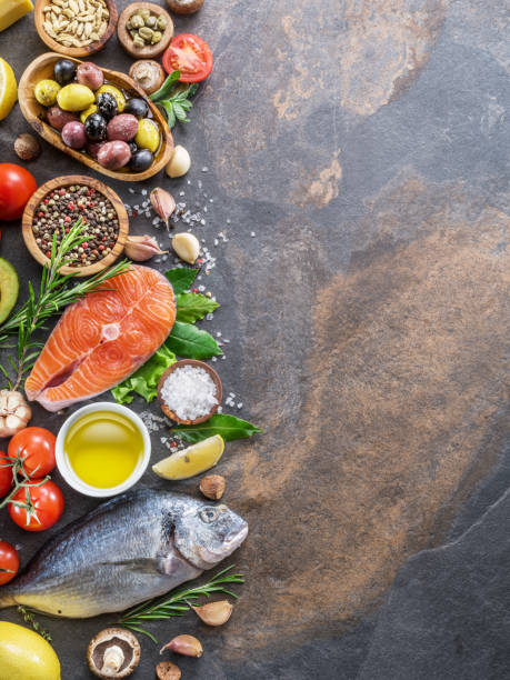 istock Raw dorado fish and salmon steak with spices and vegetables. 1129211252