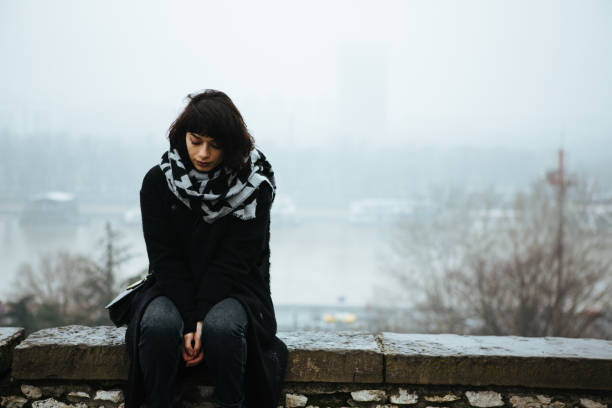 Girl, alone. Girl sitting on a wall and having a tough time bipolar disorder stock pictures, royalty-free photos & images