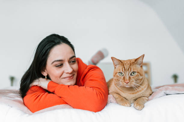istock Young woman with her cat in bed 1129211842