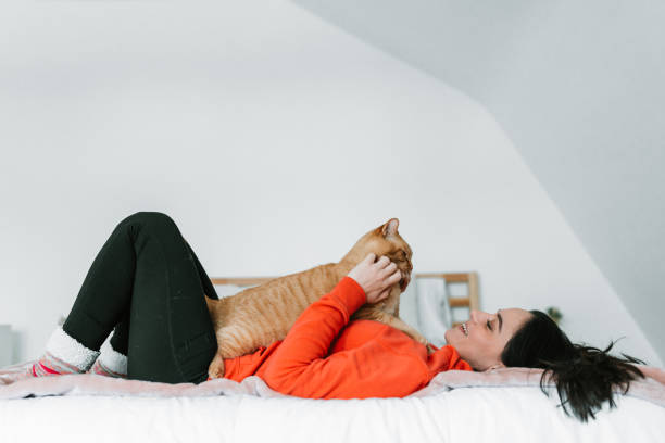 istock Young woman with her cat in bed 1129211861