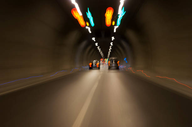 istock Long exposure tunnel with lights and speed limit signs. 1129212727