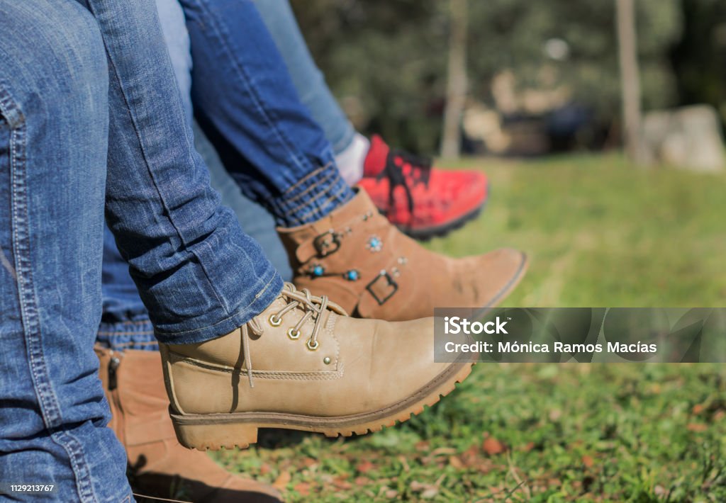 Woman legs crossed with cowboy pants and boots Woman legs crossed with cowboy pants and boots in the field Backgrounds Stock Photo