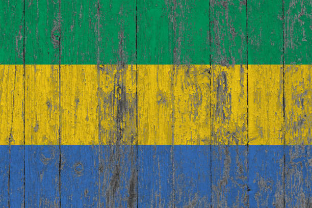 Flag of Gabon painted on worn out wooden texture background.