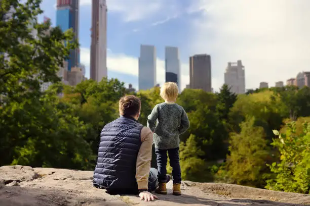 Photo of Man and her charming little son admire the views in Central Park, new York