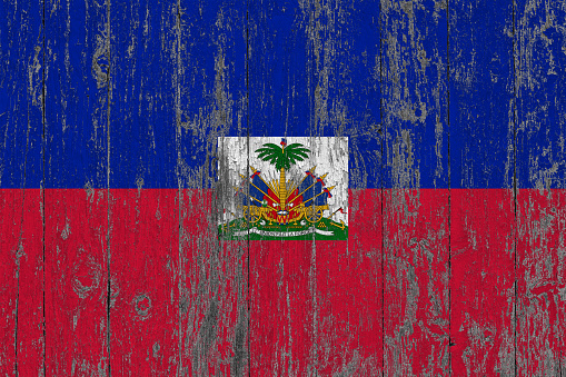 Flag of Haiti painted on worn out wooden texture background.
