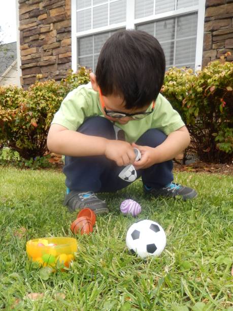 istock Series 1: Little Boy Taking Candy Out of a Plastic Egg 1129225595
