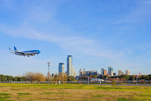 Buenos Aires, Argentina, June 18, 2018: Airplane landing in Buenos Aires at the city center airport, skyscrapers of the modern business district Puerto Madero in the background, Argentina, South America