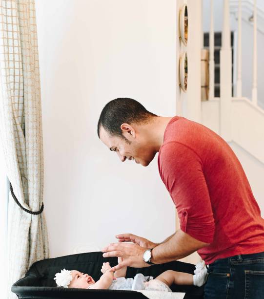 istock Latino father in his 20’s changes his infant daughter 1129228582