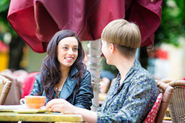 istock Young women chatting outdoors at street cafe 1129229836