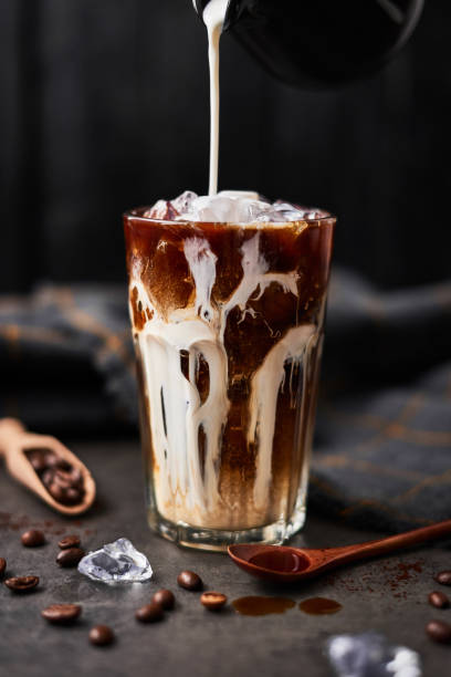 istock Ice coffee in a tall glass with cream poured over 1129231040