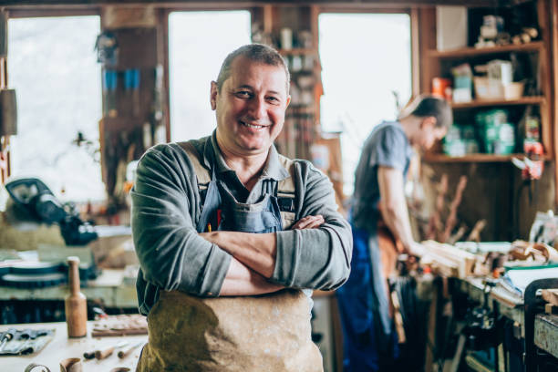 Portrait of Senior Carpenter Happy professional craftsman standing in wood workshop carpenter portrait stock pictures, royalty-free photos & images