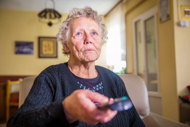 istock Senior woman holding remote control 1129233364