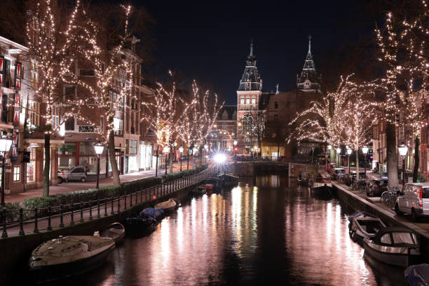 istock AMSTERDAM, NETHERLANDS - DECEMBER 12, 2018: illuminated trees and buildings reflected in water at Spiegelgracht Amsterdam in december by night 1129233377