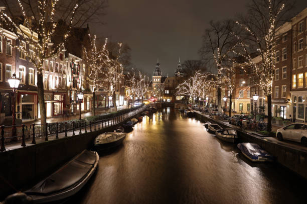 istock AMSTERDAM, NETHERLANDS - JANUARY 7, 2019: illuminated trees and buildings reflected in water at Spiegelgracht Amsterdam in december by night 1129233909