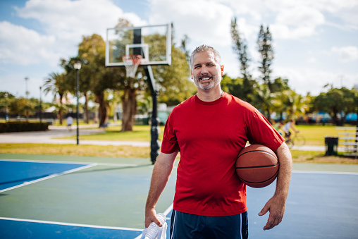 Mature man exercising outdoors in Miami, USA. Mature 50-55 year old man with gray hair exercising to lose weight an to keep his body healthy.