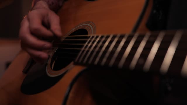 Unrecognizable musician playing acoustic guitar