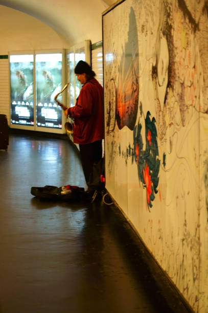 Paris, France - December 31, 2013: A street musician plays saxophone in the aisles of the Parisian subway on December 31, 2013 in Paris.\