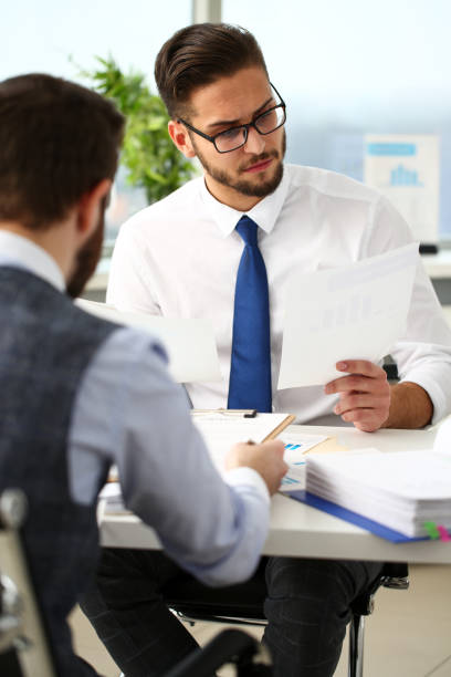 istock Group of businessmen with financial graph in arm solve and discuss problem 1129246917