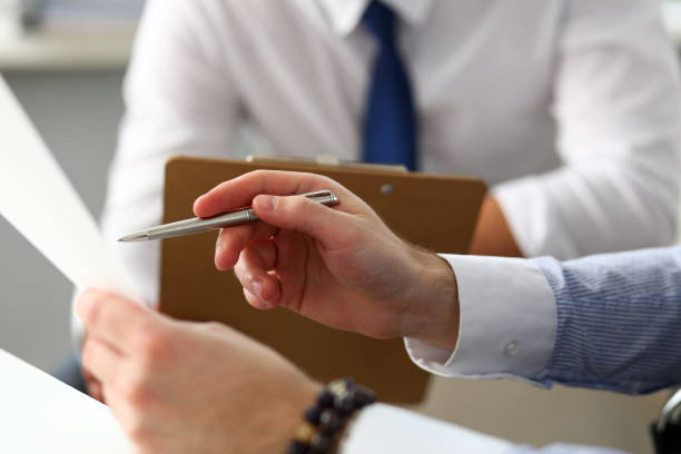 istock Group of businessmen with financial graph and silver pen 1129246919