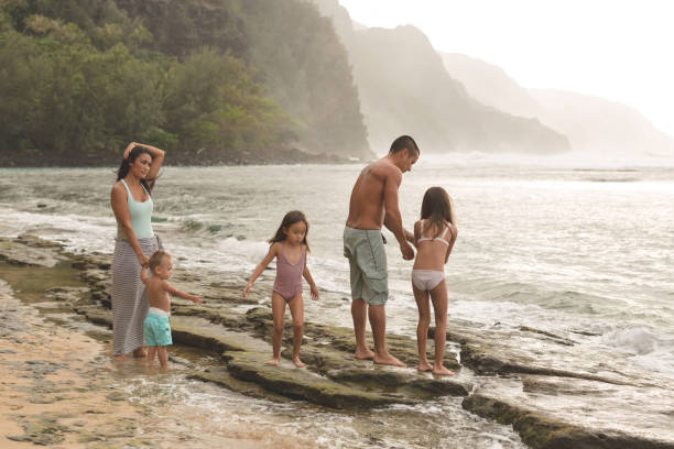 istock Ethnic family with three children playing together on a sandy beach 1129246983