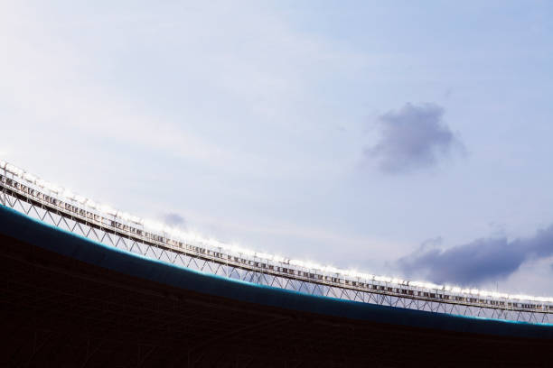 istock Spotlights and floodlights at a stadium at dusk 1129249741