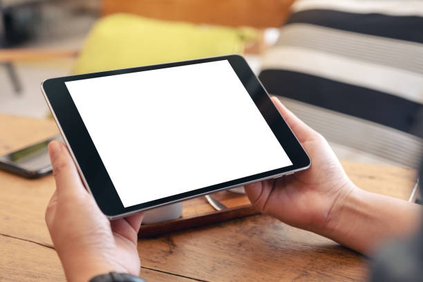 istock a woman's hands holding black tablet pc with blank white screen 1129256719