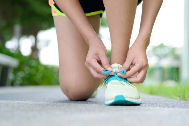 Woman exercise run  she tying shoelaces at the running track. Health and Sports Concepts Woman exercise run  she tying shoelaces at the running track. Health and Sports Concepts lace up stock pictures, royalty-free photos & images