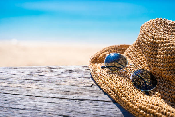 istock hat and sunglasses on timber and the sea blackground 1129262672