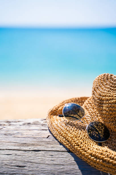 istock hat and sunglasses on timber and the sea blackground 1129262674