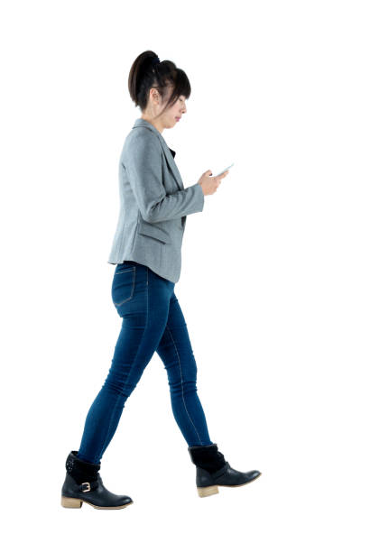 istock Busy businesswoman walking and using phone 1129270384