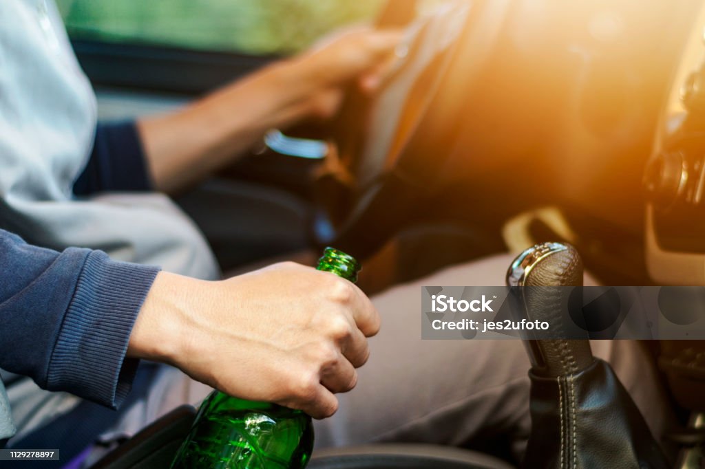 Drinking and driving ,man drinking alcohol and using mobile phone while driving car ,concept drive safely while using a cell phone or drunk alcohol Drinking and driving ,man drinking alcohol and using mobile phone while driving car ,concept drive safely while using a cell phone or drunk alcohol. Drunk Driving Stock Photo